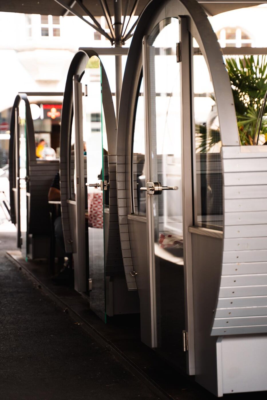 Reihe der Terrassenfässer (Outdoor-Boxen) mit Glastüren vor der Bar